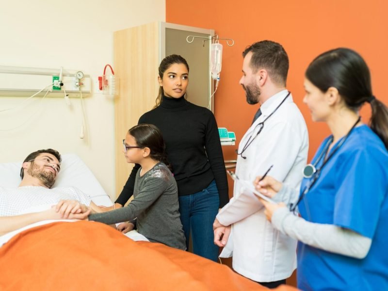 doctor-nurse-explaining-disease-woman-while-standing-by-sick-man-hospital_662251-3049